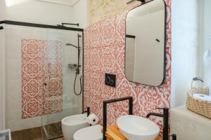 a bathroom with a shower and a sink and a mirror at Spighe e Fenicotteri in Modica +25 photos