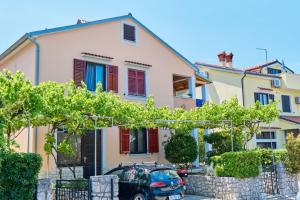 a house with a car parked in front of it at Apartments Ady in Mali Lošinj
