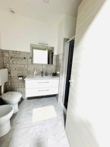 a bathroom with a toilet and a sink and a mirror at Ali apartments in Pizzo
