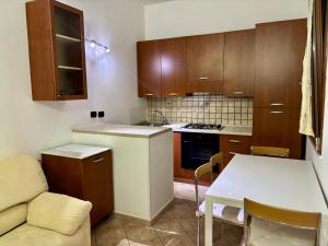 a kitchen with wooden cabinets and a table and a couch at Casa Mia in Augusta