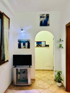 a living room with a television and an arched doorway at Casa Mia in Augusta