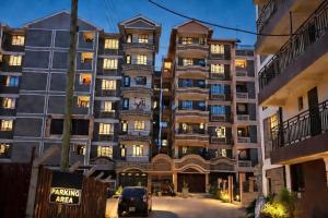 a large apartment building with a car parked in front at Cozy cloud in Ruiru