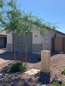 a tree in front of a house with a building at Todd's Relaxation Place in Maricopa