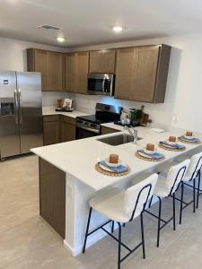 a kitchen with a large island with chairs and a counter top at Todd's Relaxation Place in Maricopa
