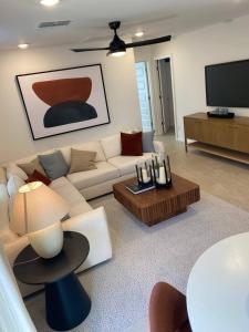 a living room with a white couch and a tv at Todd's Relaxation Place in Maricopa