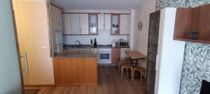 a kitchen with white cabinets and a wooden floor at Calle Maceiras, 1 - 1B in Combarro