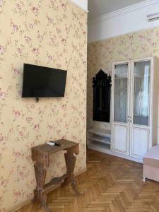 a living room with a television on a wall with flowers at Grecheskaya Central Suites in Odesa
