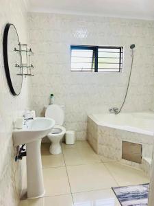 a bathroom with a sink and a tub and a toilet at Aurum Stays in Gaborone +54 photos