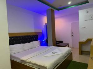 a bedroom with a large bed with purple lighting at Hotel Glitter in Guwahati