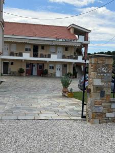 a large building with a stone patio in front of it at Flo's Apartments in Missolonghi +5 photos