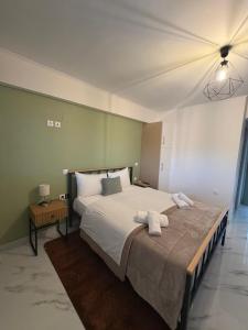 a bedroom with a large bed with two towels on it at Flo's Apartments in Missolonghi