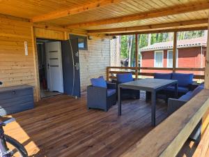 a patio with a table and chairs on a deck at Oto Domek 2 in Międzyrzecz