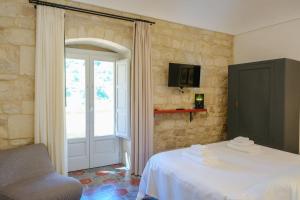a bedroom with a bed and a window and a chair at Spighe e Fenicotteri in Modica