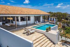 a villa with a swimming pool and a house at Luxe Villa met Panoramisch Zeezicht op Bonaire - Kas Ubuntu in Kralendijk