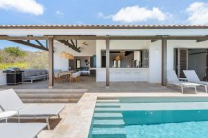 a house with a swimming pool and a patio at Luxe Villa met Panoramisch Zeezicht op Bonaire - Kas Ubuntu in Kralendijk
