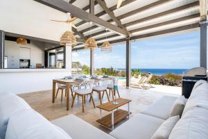an open kitchen and living room with a table and chairs at Luxe Villa met Panoramisch Zeezicht op Bonaire - Kas Ubuntu in Kralendijk +46 photos