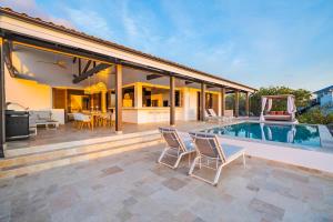 a house with a swimming pool and a patio at Luxe Villa met Panoramisch Zeezicht op Bonaire - Kas Ubuntu in Kralendijk