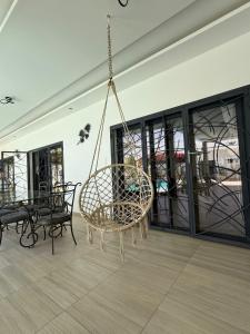 a rattan swing hanging from the ceiling in a room at Paradis in Ngaparou