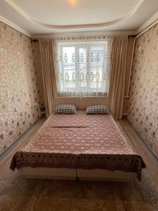 a bedroom with a large bed in front of a window at Daniel guesthouse in Kochkorka