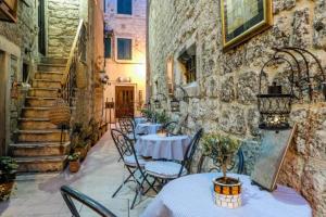a patio with tables and chairs in an alley at Apartments Festum in Šibenik