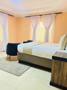 a bedroom with a large bed and a window at Aurum Stays in Gaborone