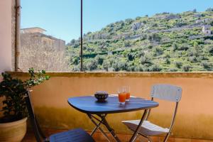 a blue table and chairs on a balcony with a mountain at Spighe e Fenicotteri in Modica