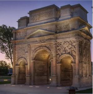 a large stone building with arches in a park at Umalas studio in Orange +5 photos