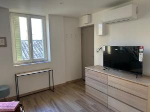 a living room with a flat screen tv on a dresser at Umalas studio in Orange