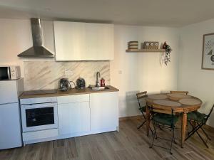 a kitchen with a small table and a kitchen with white cabinets at Umalas studio in Orange