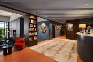 a lobby with a bar and a red chair at Hotel Sailer in Innsbruck
