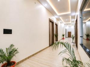 a hallway with potted plants in an office building at Hotel JB Square Ayodhya Near Ram Mandir, Airport & Ayodhya Cantt in Ayodhya +19 photos
