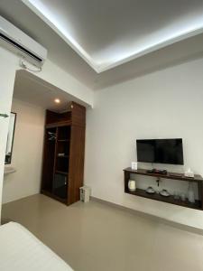 a bedroom with a flat screen tv on the wall at Villa GHANIA in Labuanbalat