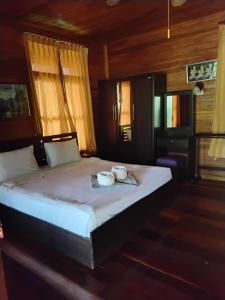 a bedroom with a bed with two cups on it at Bangsaray Village Resort in Ban Nong Chap Tao