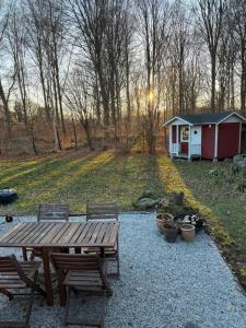 a wooden picnic table and chairs in a yard at Skogsnära boende i Ludvigsborg in Ludvigsborg