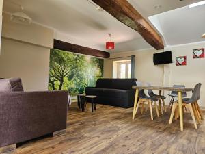 a living room with a couch and a table at Gites de groupes Les Muriers in Bourgvilain