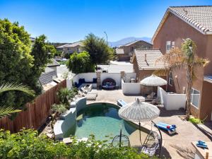 a backyard with a swimming pool and a house at NEWGamesTVsHeated PoolFirepitFireplace in Coachella