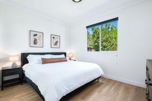 a white bedroom with a bed and a window at NEWGamesTVsHeated PoolFirepitFireplace in Coachella +34 photos