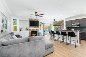 a living room and kitchen with a couch and a fireplace at NEWGamesTVsHeated PoolFirepitFireplace in Coachella