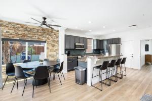 a kitchen and dining room with a table and chairs at NEWGamesTVsHeated PoolFirepitFireplace in Coachella