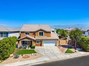 a brick house with a garage in a neighborhood at NEWGamesTVsHeated PoolFirepitFireplace in Coachella