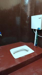 a bathroom with a white toilet in a stall at singh homestay in Varanasi
