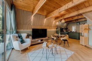 a living room with a couch and a tv at Maroska Pine in Kismaros
