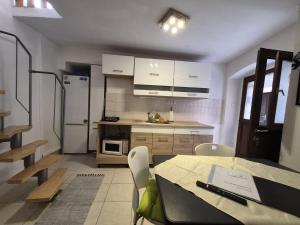 a kitchen with white cabinets and a table with chairs at Apartment Sidro in Cres +15 photos