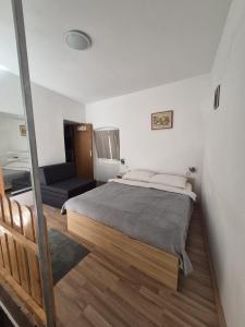 a bedroom with a large bed and a couch at Apartment Sidro in Cres