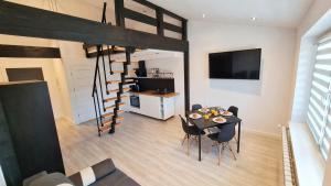 a living room with a table and a loft bed at Dream Apartments 1B KLIMATYZACJA in Oświęcim