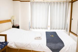 ein Schlafzimmer mit einem Bett, an dem eine blaue Krawatte hängt in der Unterkunft otani 201 in Osaka