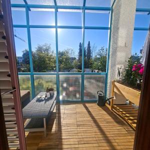 a room with a large window and a bench on a balcony at Estelada Studios Unterhaching in Unterhaching