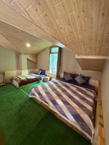 a bedroom with a large bed with a wooden ceiling at Sparrow Whisper in Jibhi +9 photos