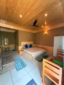a bedroom with two beds and a ceiling fan at Sparrow Whisper in Jibhi