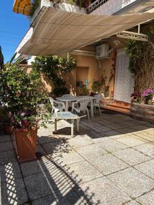 eine Terrasse mit Tisch, Stühlen und Sonnenschirm in der Unterkunft Clio 21 in Marina di Massa